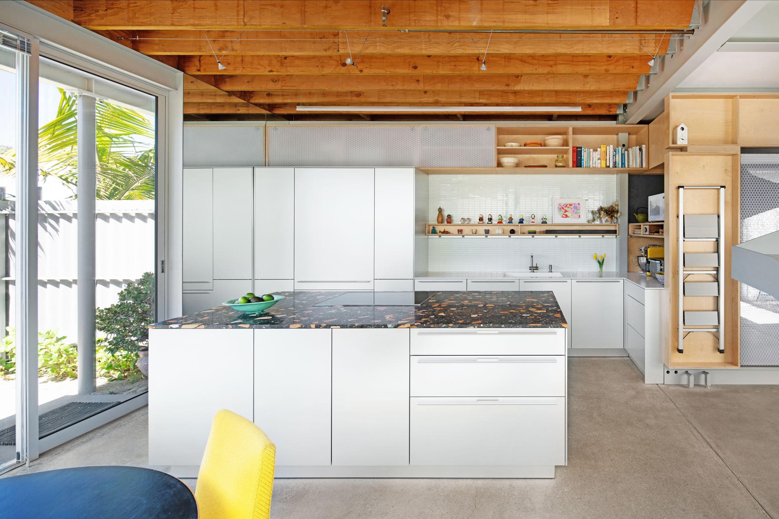 Clean minimalist kitchen with white cabinetry and exposed wooden ceiling beams.