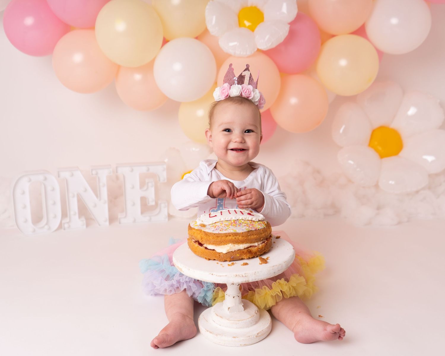 first birthday one year old cake smash with pastel flowers and cake by professional newborn photographer in Doncaster.
