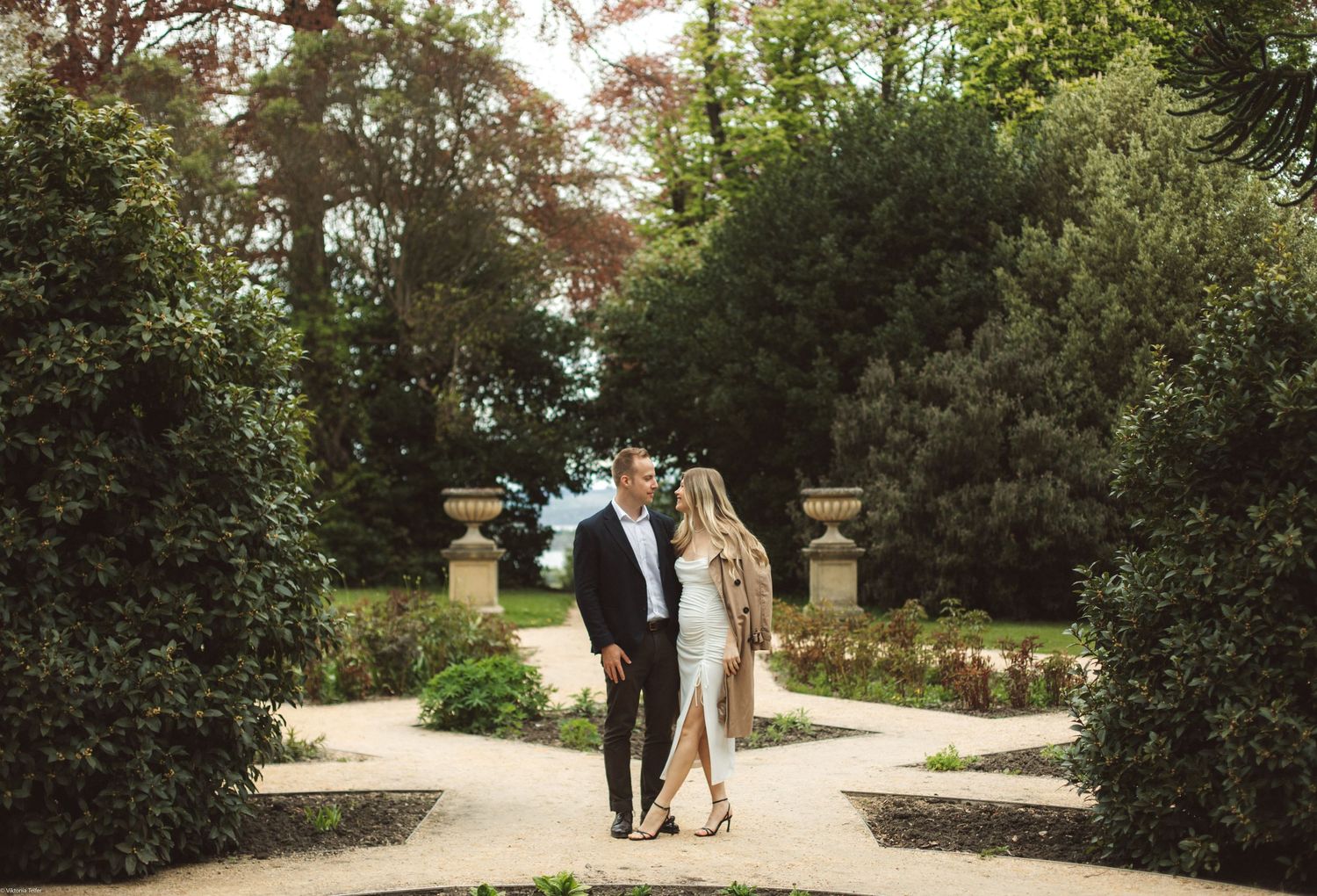 A scenic garden pathway lined with lush greenery and trees.