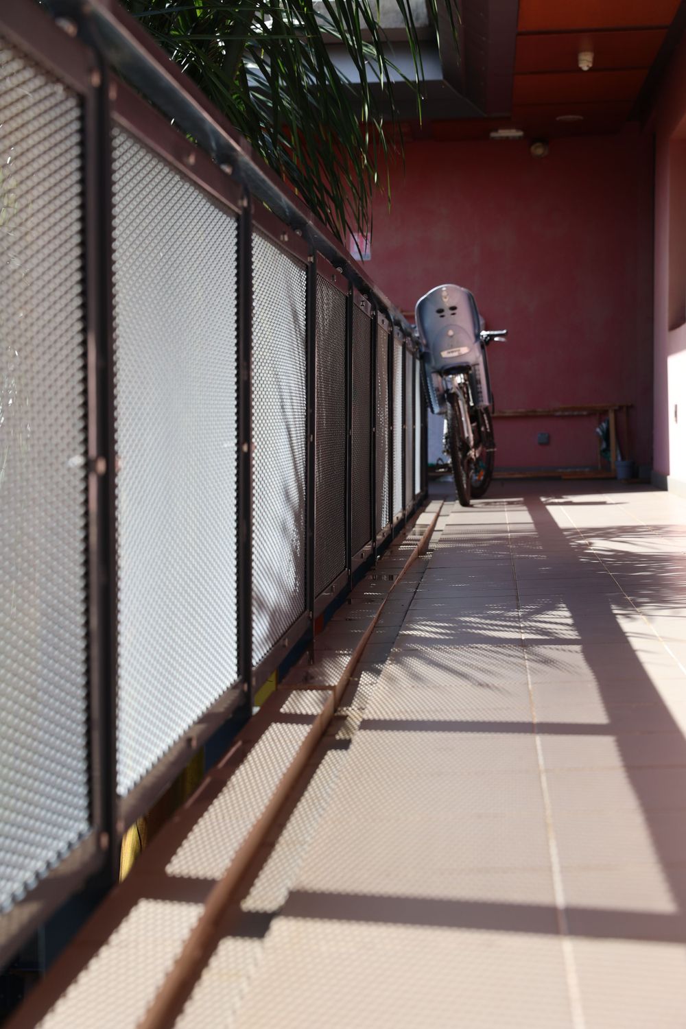 Long corridor with metal shutters and dramatic lighting creating geometric shadows.