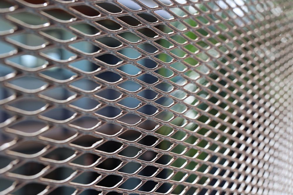 Close-up pattern of metallic mesh creating repetitive diamond shapes.