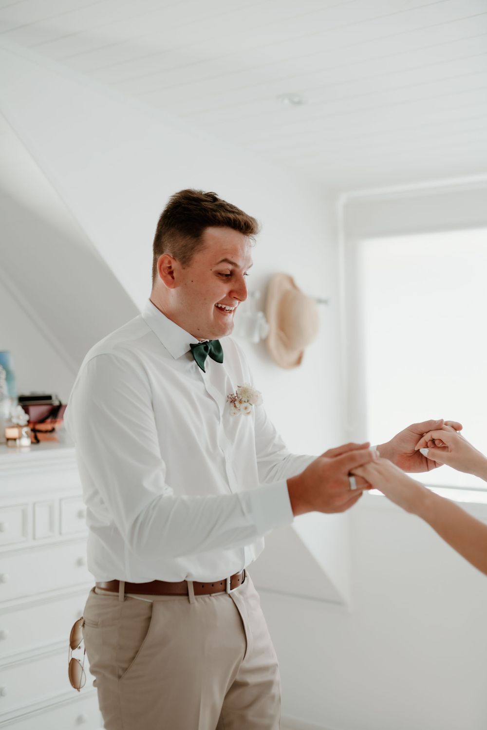 Joyful moment during wedding preparation in bright indoor setting.