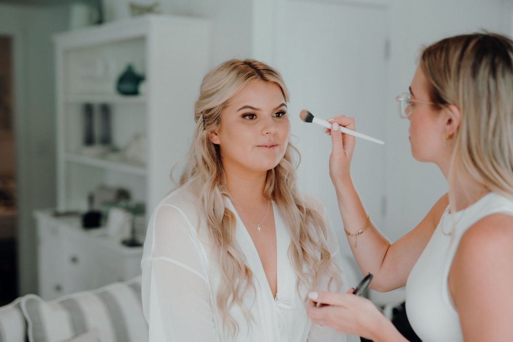 Makeup artist applying cosmetics during bridal preparation.
