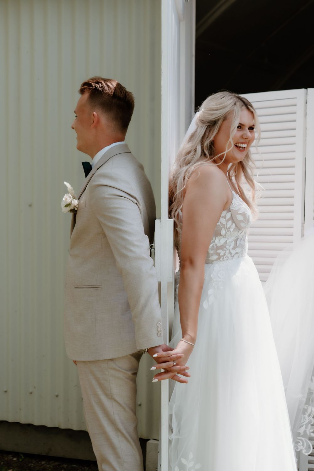 First look between couple with bride in lace dress and groom in light suit.