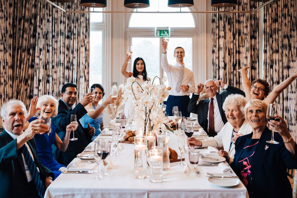 Cowley Manor lovely happy photograph of wedding guests waving goodbye at the dinner table