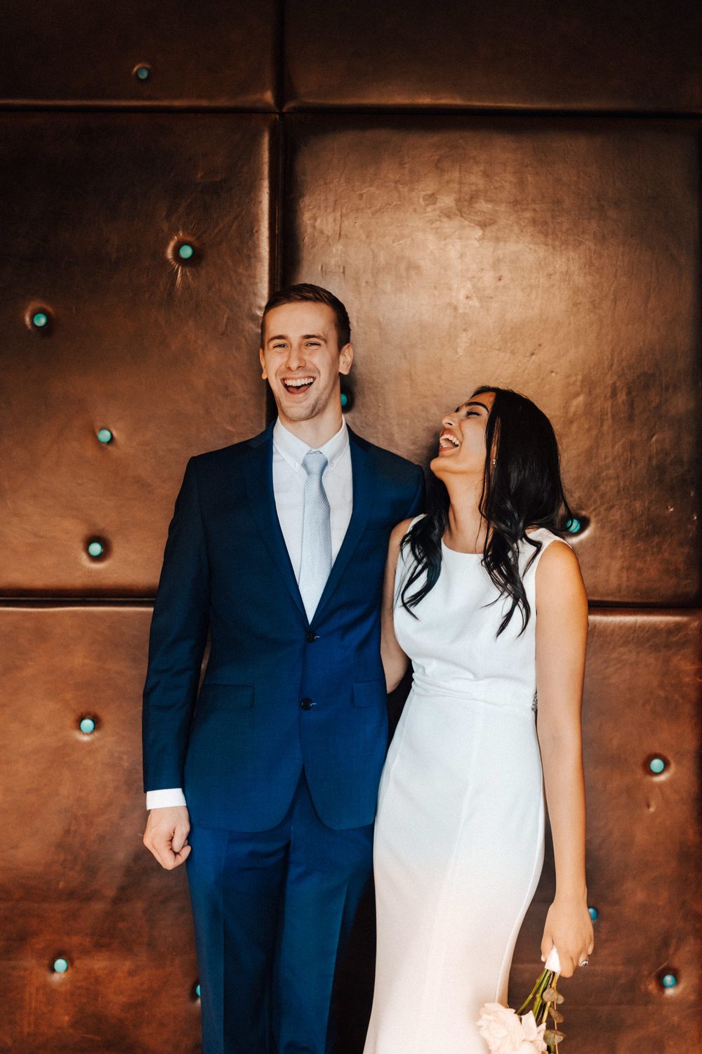 Portrait of bride and groom inside Cowley Manor looking very happy sunny day