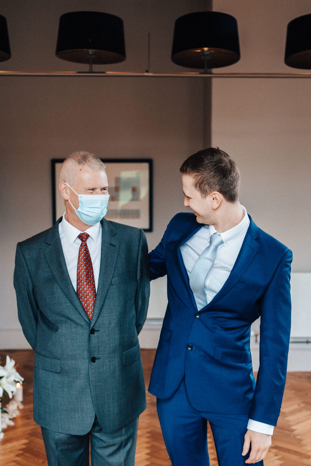 Covid wedding groom and his father having a talk father wearing face mask