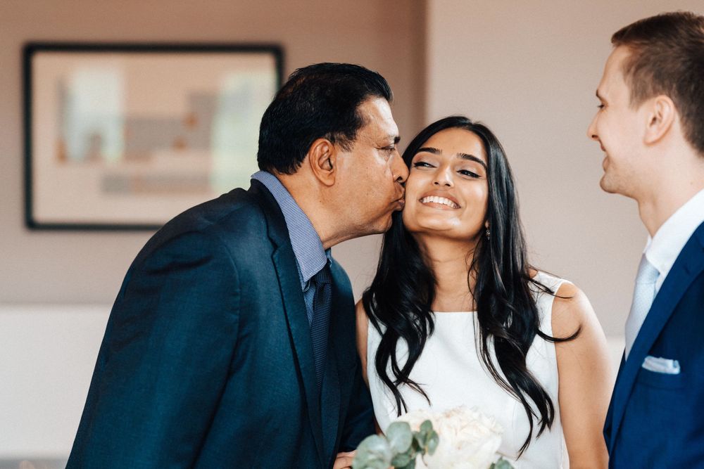Father of the bride kissing the bride before he hands her to the groom