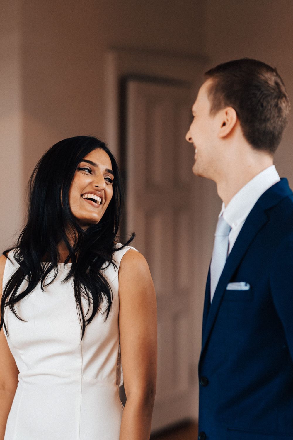 Candid wedding photograph of the ceremony at Cowley Manor bride looking over shoulder very happy