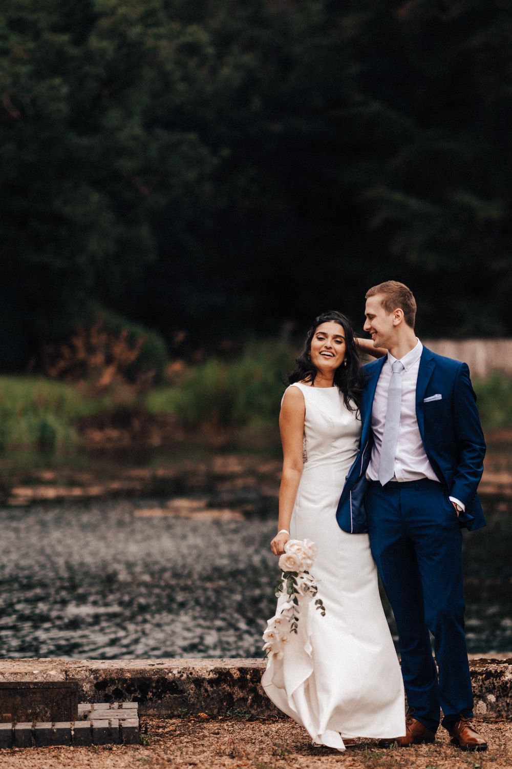 Bride and groom portrait taken at the lake at Cowley Manor