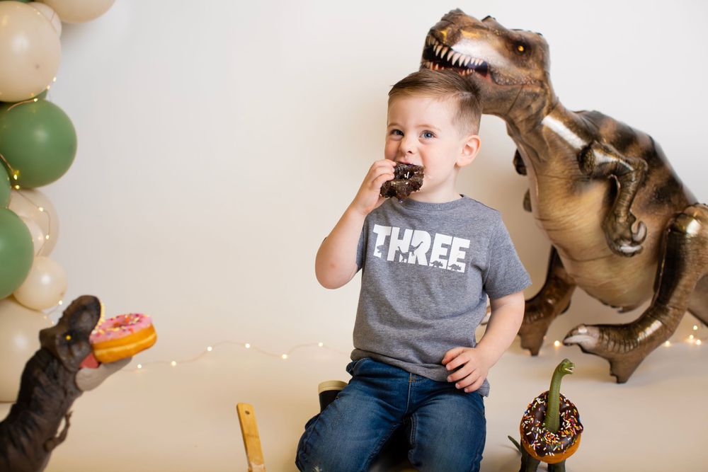 Playful dinosaur themed celebration setup with balloon decorations and treats.