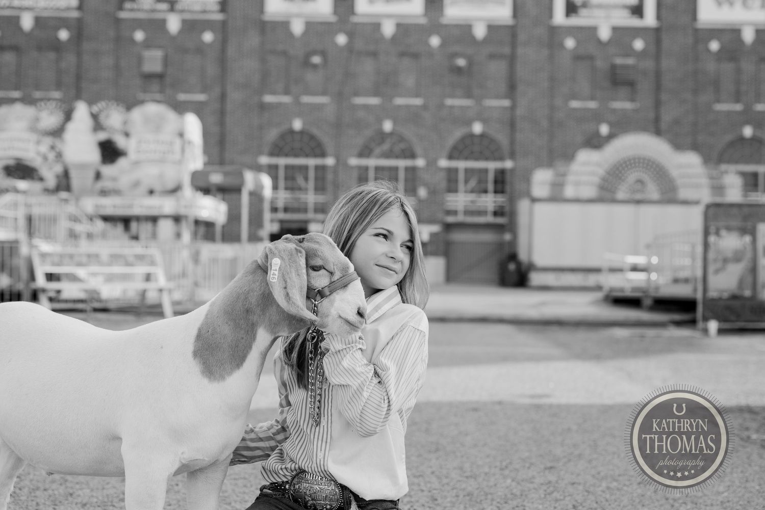 A young exhibitor poses with her show animal at the county fair in black and white.