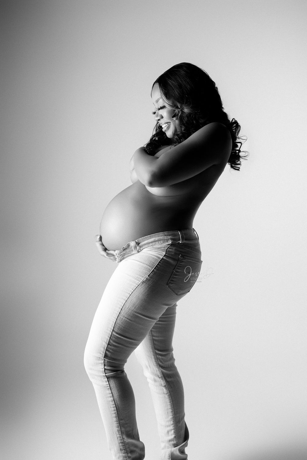 Black and white portrait of mother to be in studio.