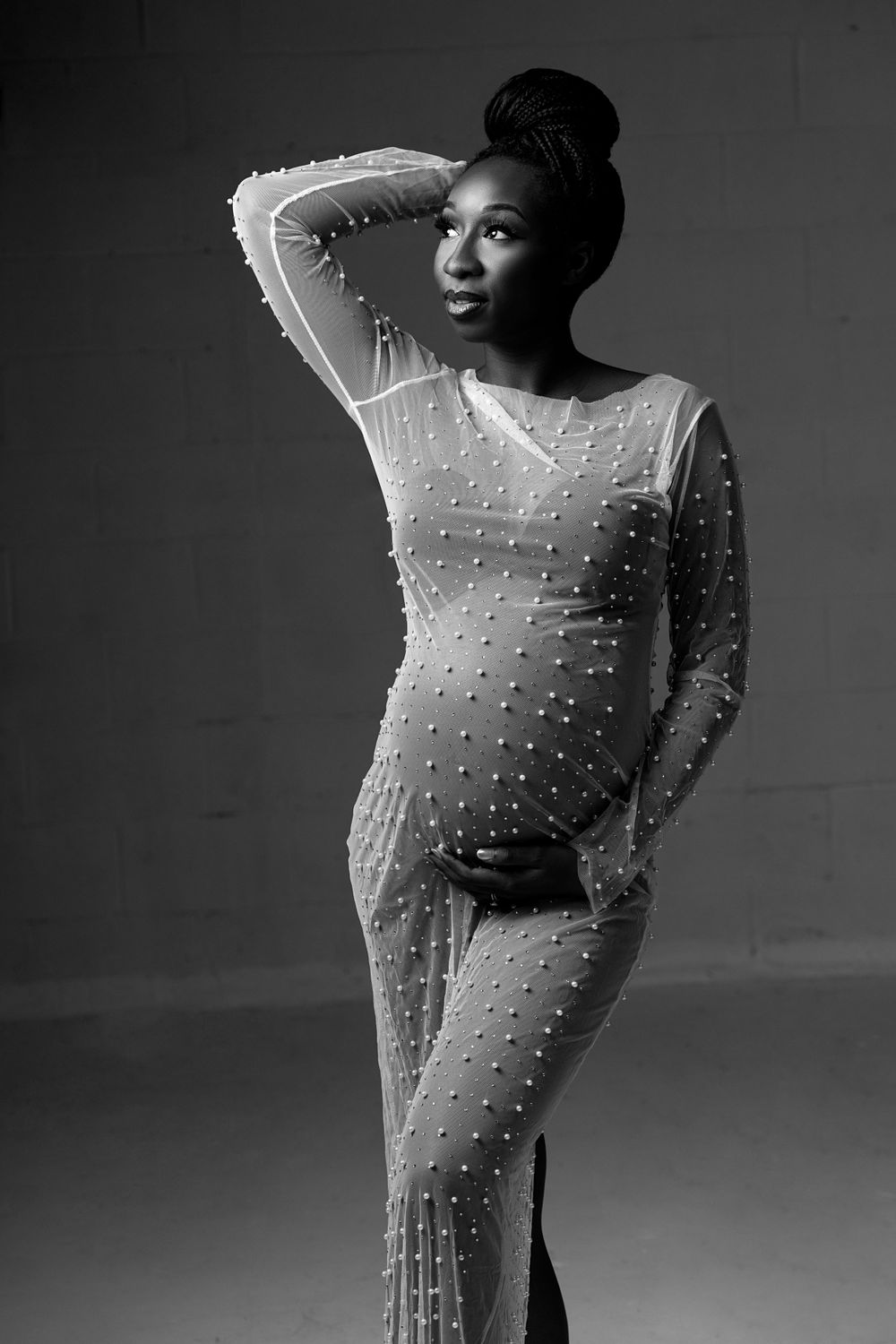 Black and white image of mother to be in a pearl beaded gown.