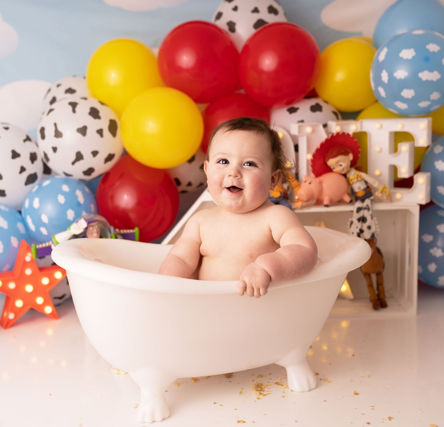 Baby boy in bath at his cake smash photographed by newborn photographer swansea