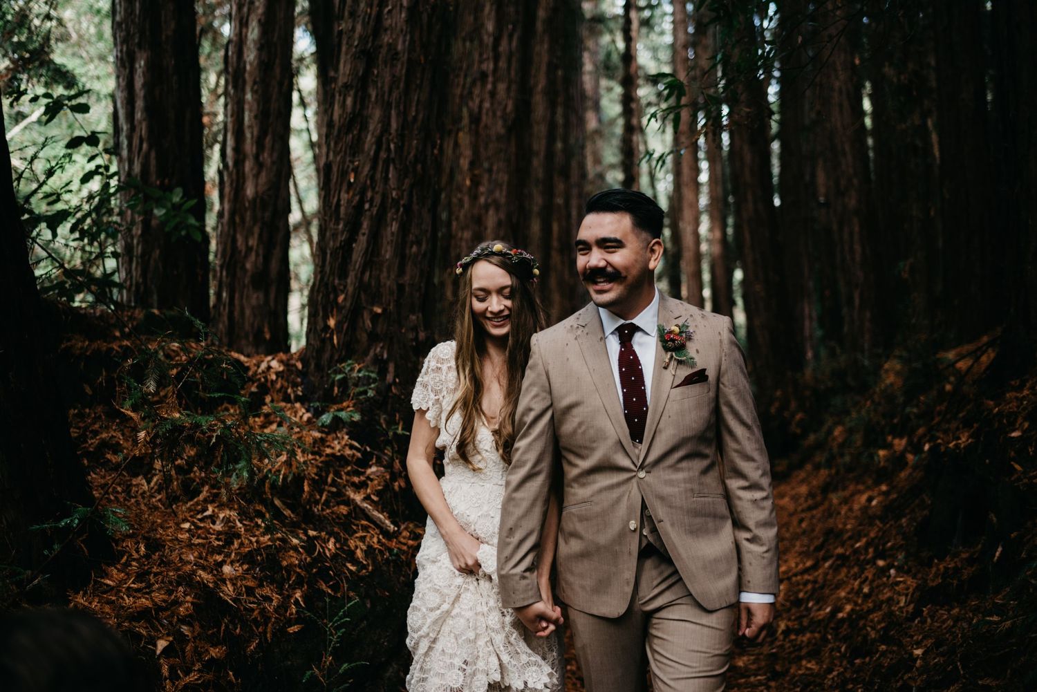 Bride and Groom joyfully walking through Santa Cruz redwood forest hand in hand