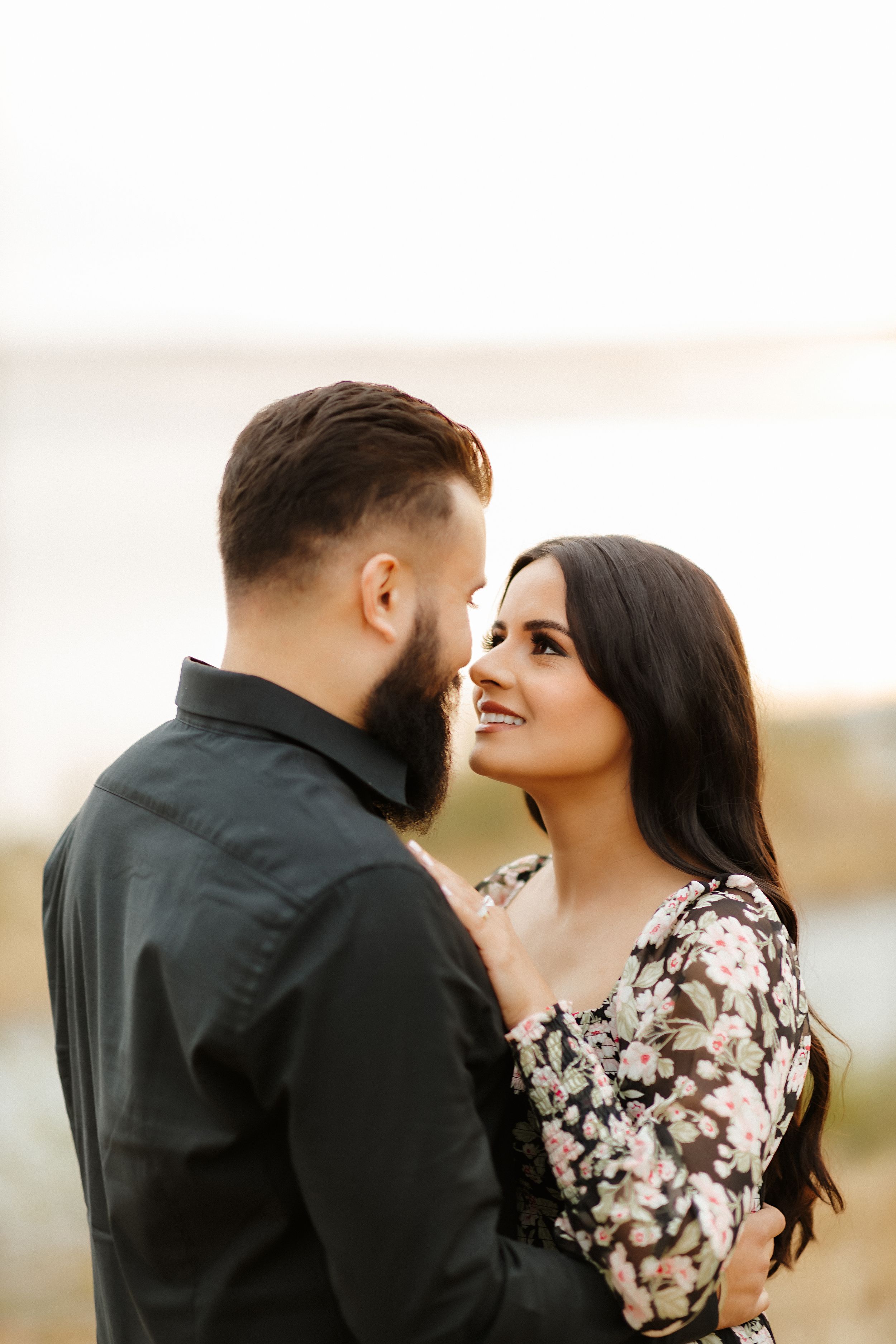 Intimate portrait of couple gazing at each other outdoors.