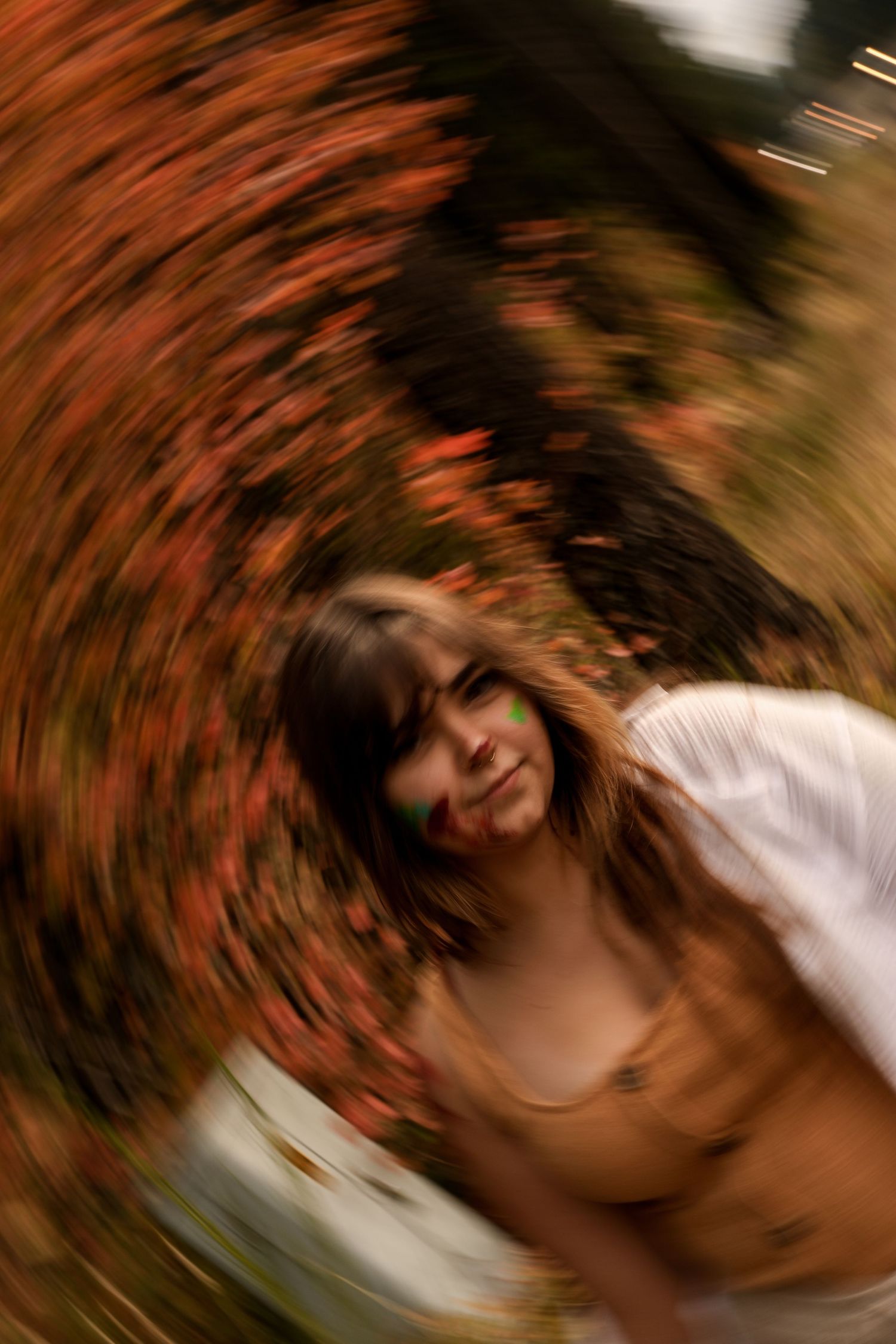 Artistic motion blur portrait with swirling autumn colors creating a dreamy effect.