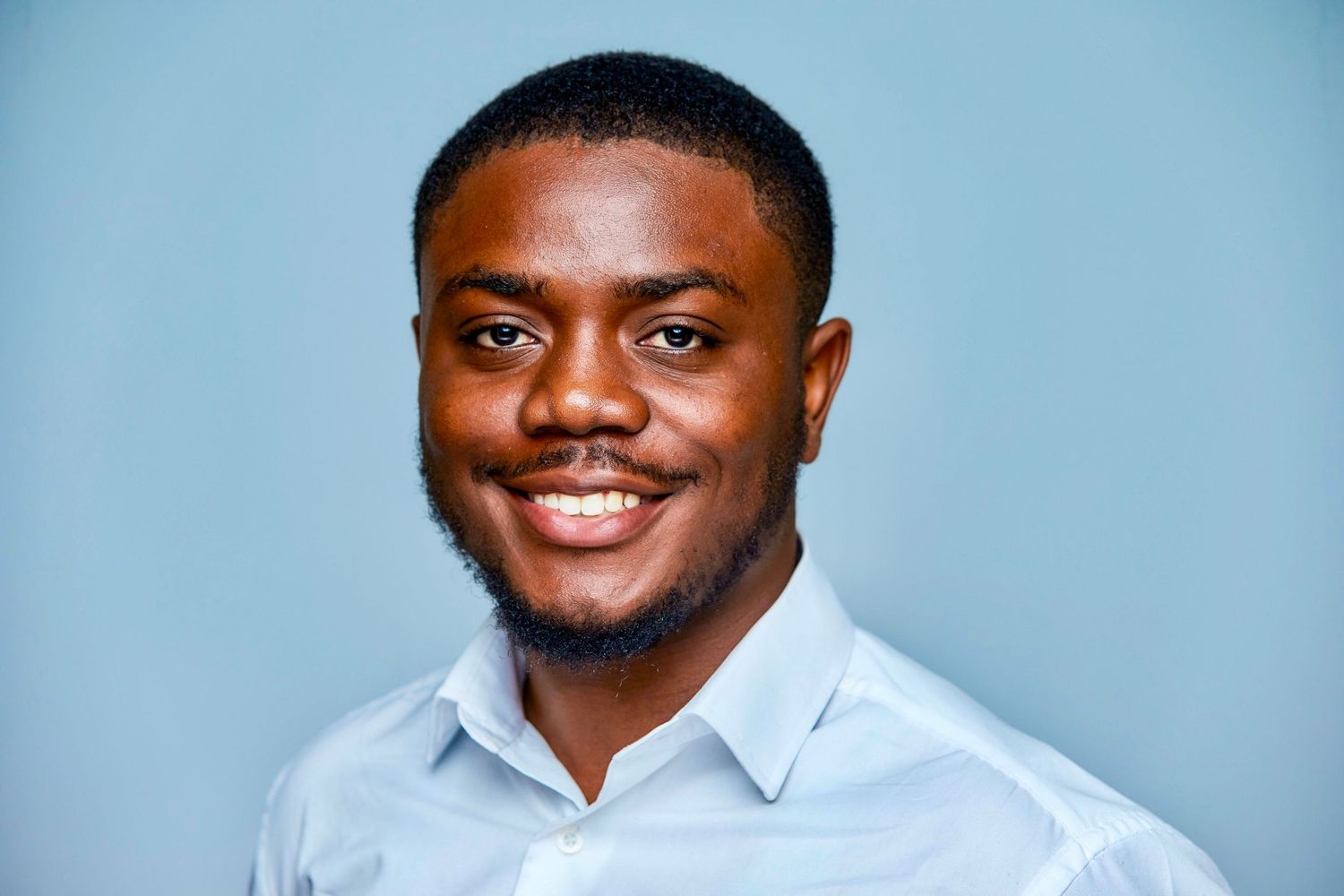 Professional headshot series against light blue background.
