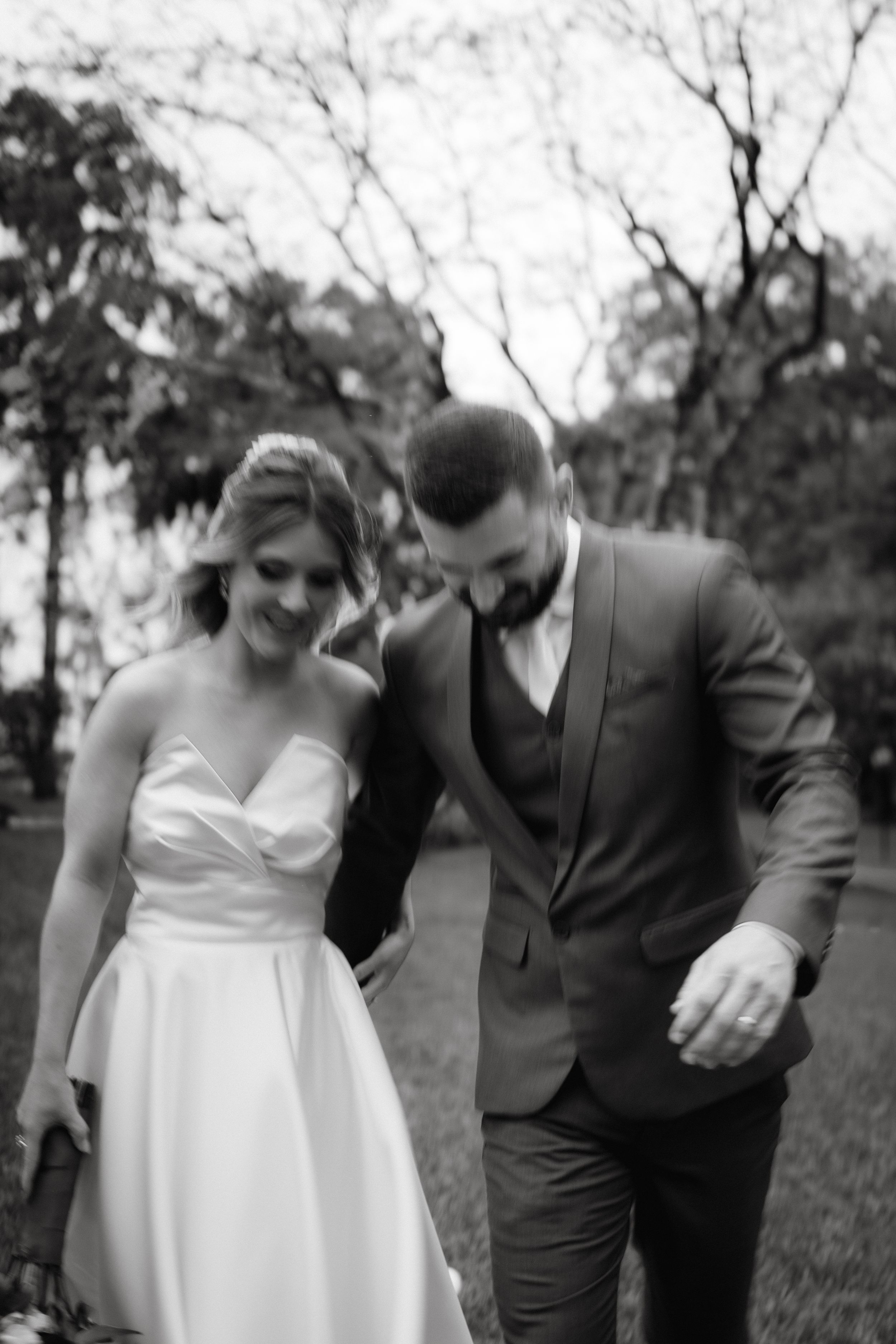 Candid black and white photo of a couple sharing a laugh during their wedding day.