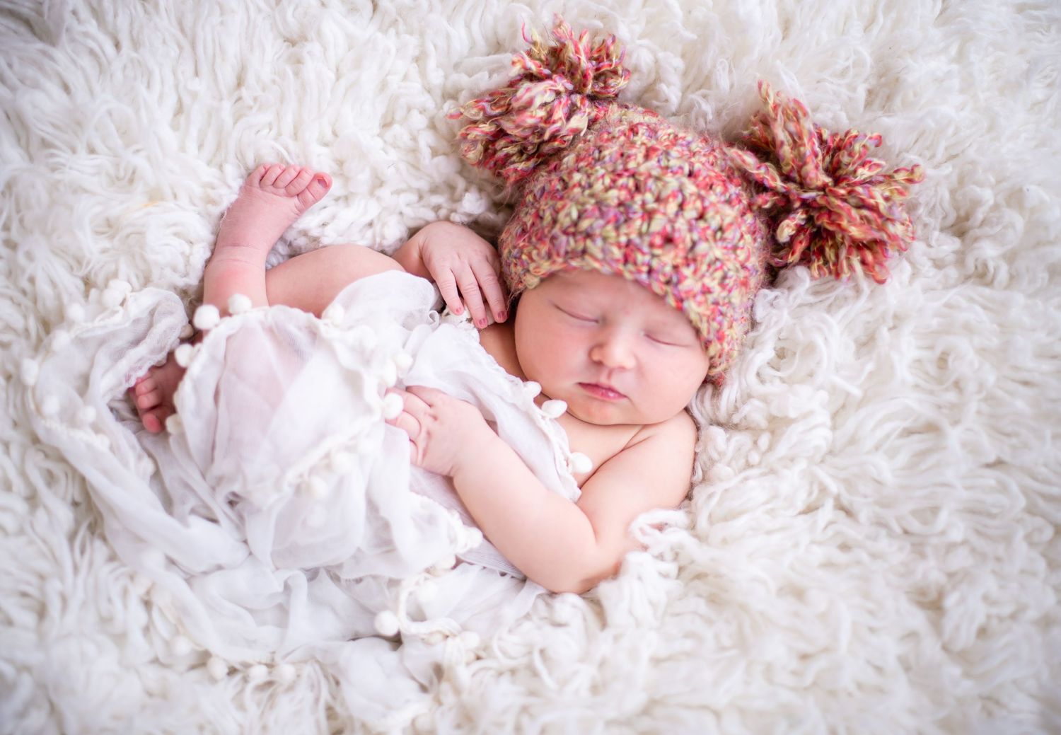 newborn baby girl pose natural light photography studio session wraps and crochet hat and custom creative set memory captured smile Alabama