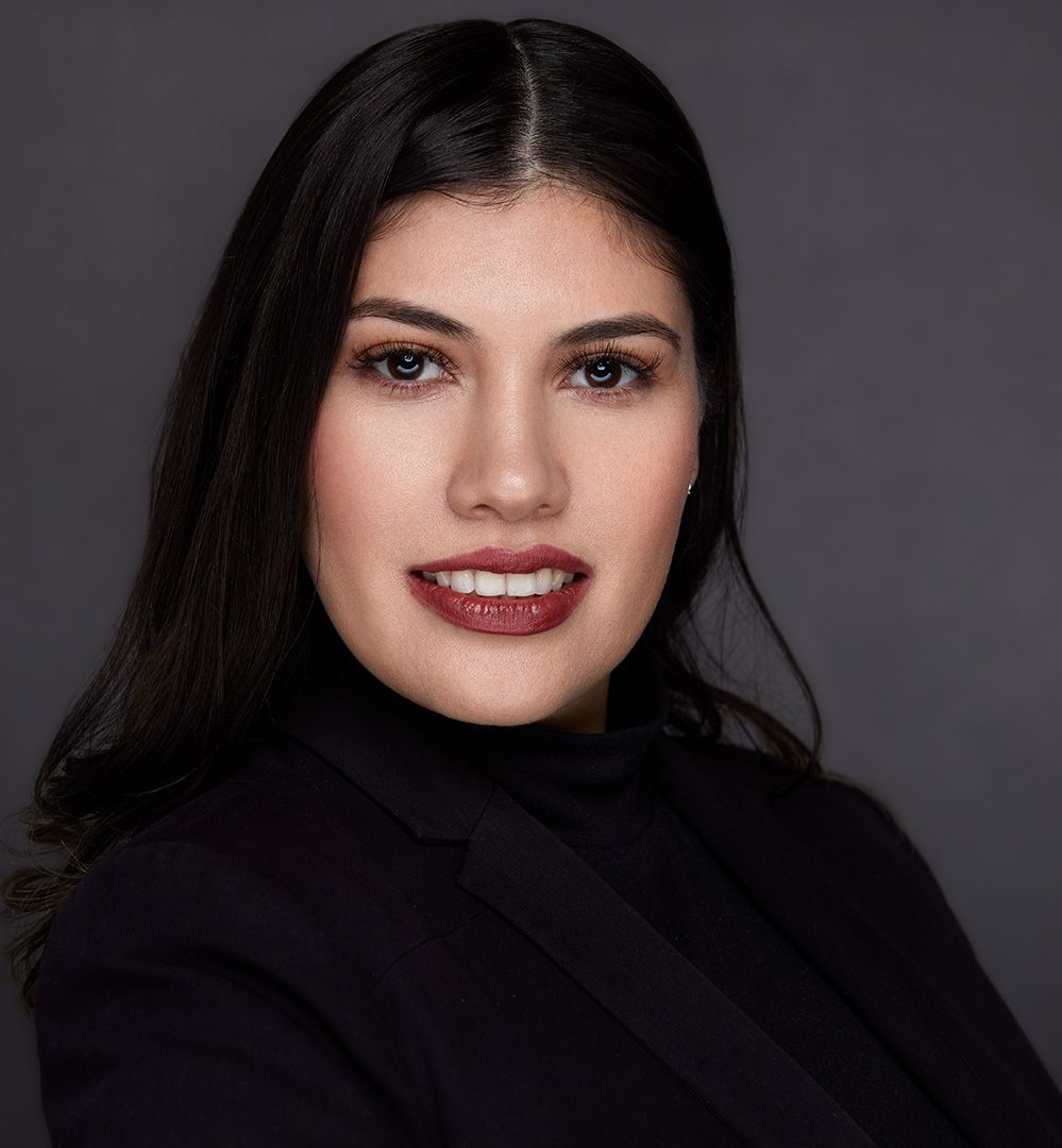 Professional beauty headshot of a woman with dark hair wearing a black turtleneck.