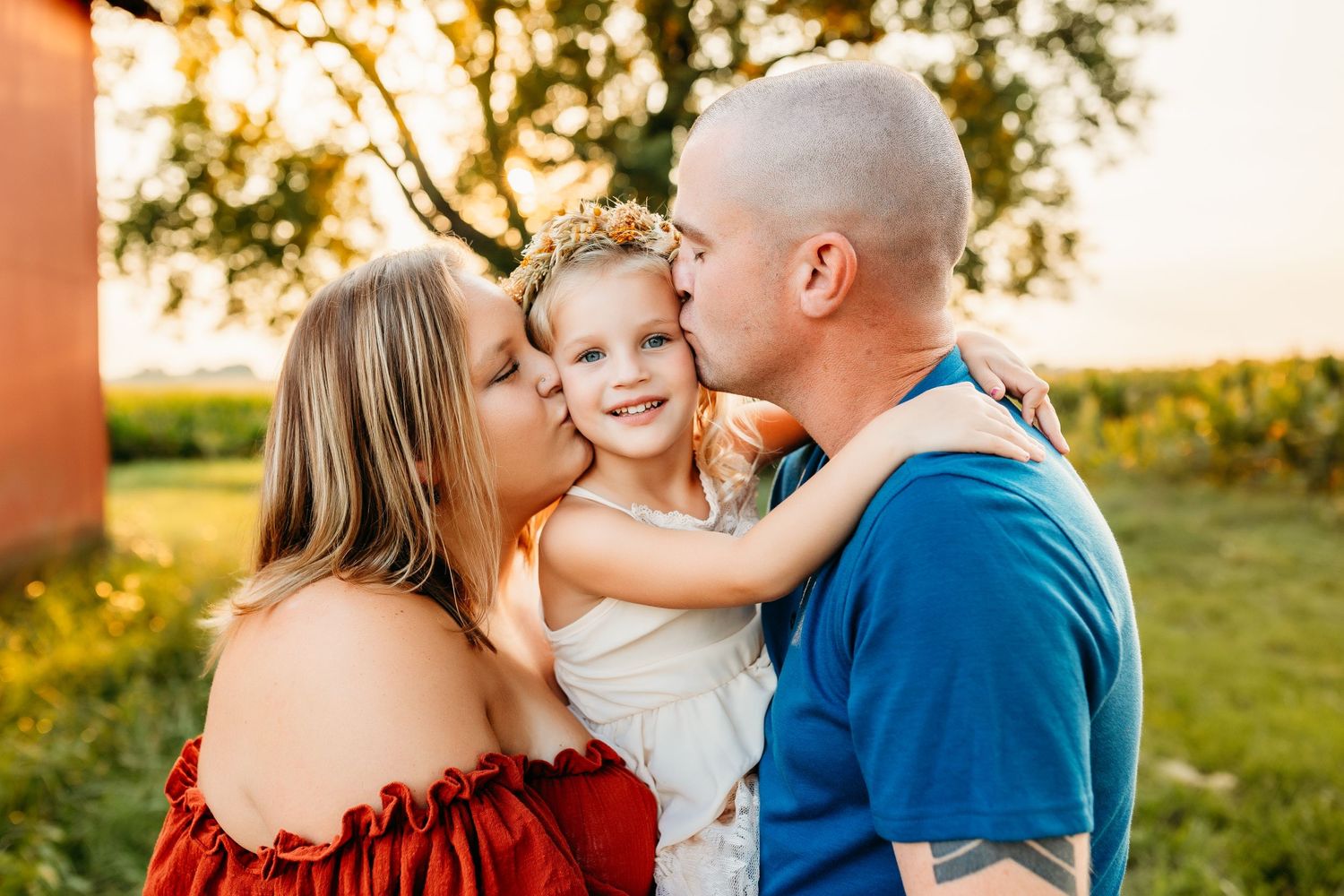 A tender family moment shared during sunset in a pastoral setting.