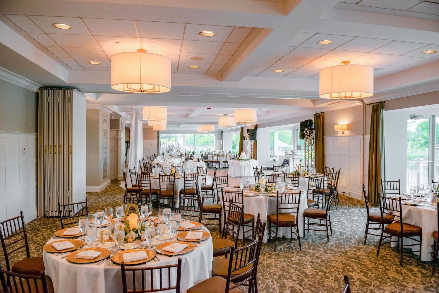 Spacious reception room with natural light and round tables set for an elegant celebration.