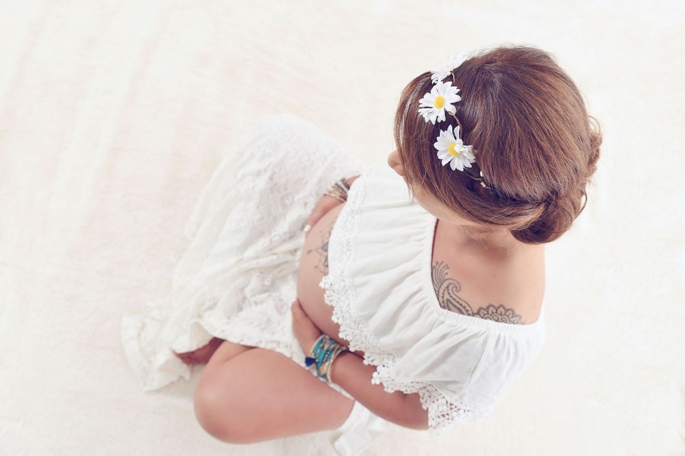 Boho styled sitting pregnant lady photographed from above