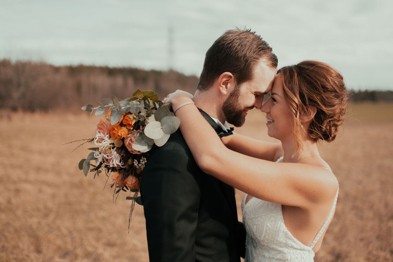 Romantic wedding portraits captured in a rustic outdoor setting with natural light.