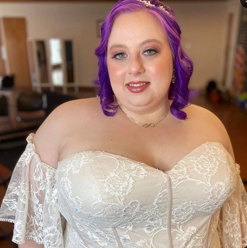 OKC bride poses showing off her beautiful dress and elegant makeup look in okc oklahoma with gaby makeup artistry