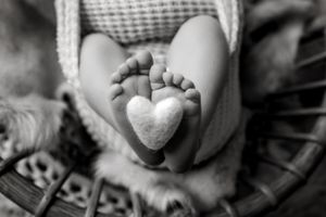 Close-up black and white detail shots of newborn baby feet.