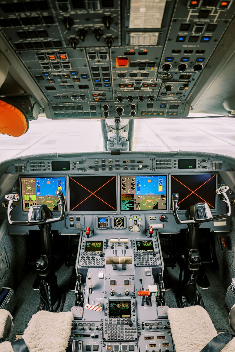 Modern aircraft cockpit with digital displays and complex control panel layout.