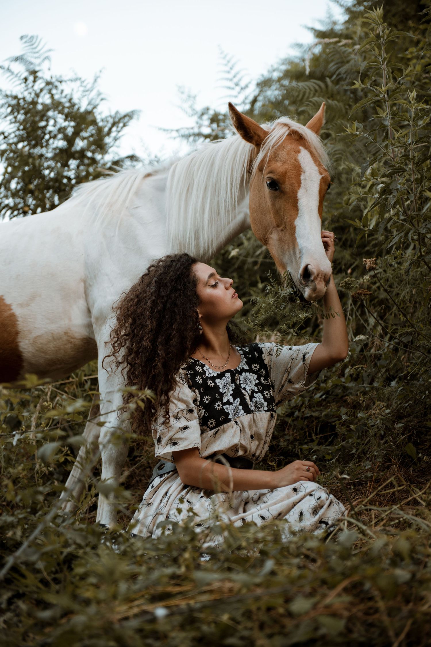 Ritratto di una ragazza naturopata con il proprio cavallo in un bosco per personal brand
