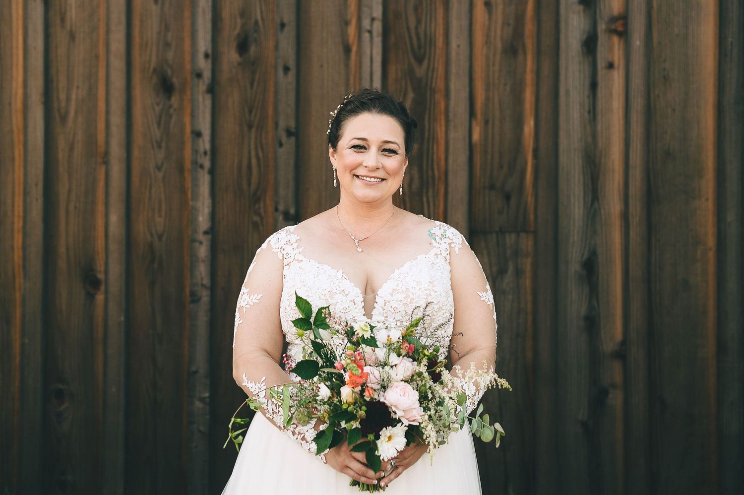 Plus size bride in beautiful lace wedding gown with bouquet.