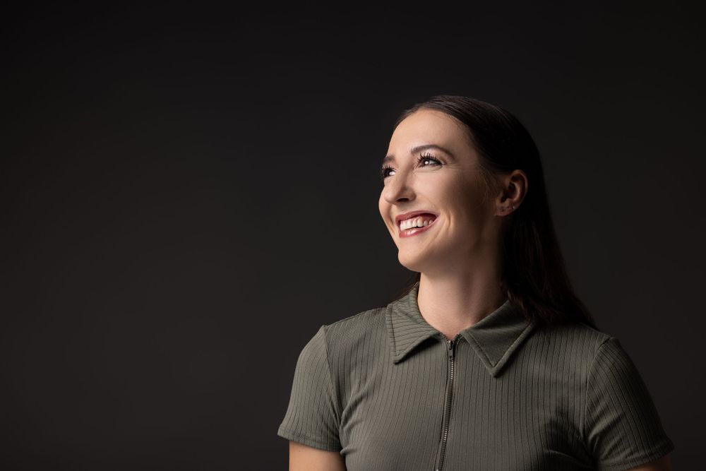 Artistic portrait series against dark background with dramatic side lighting.