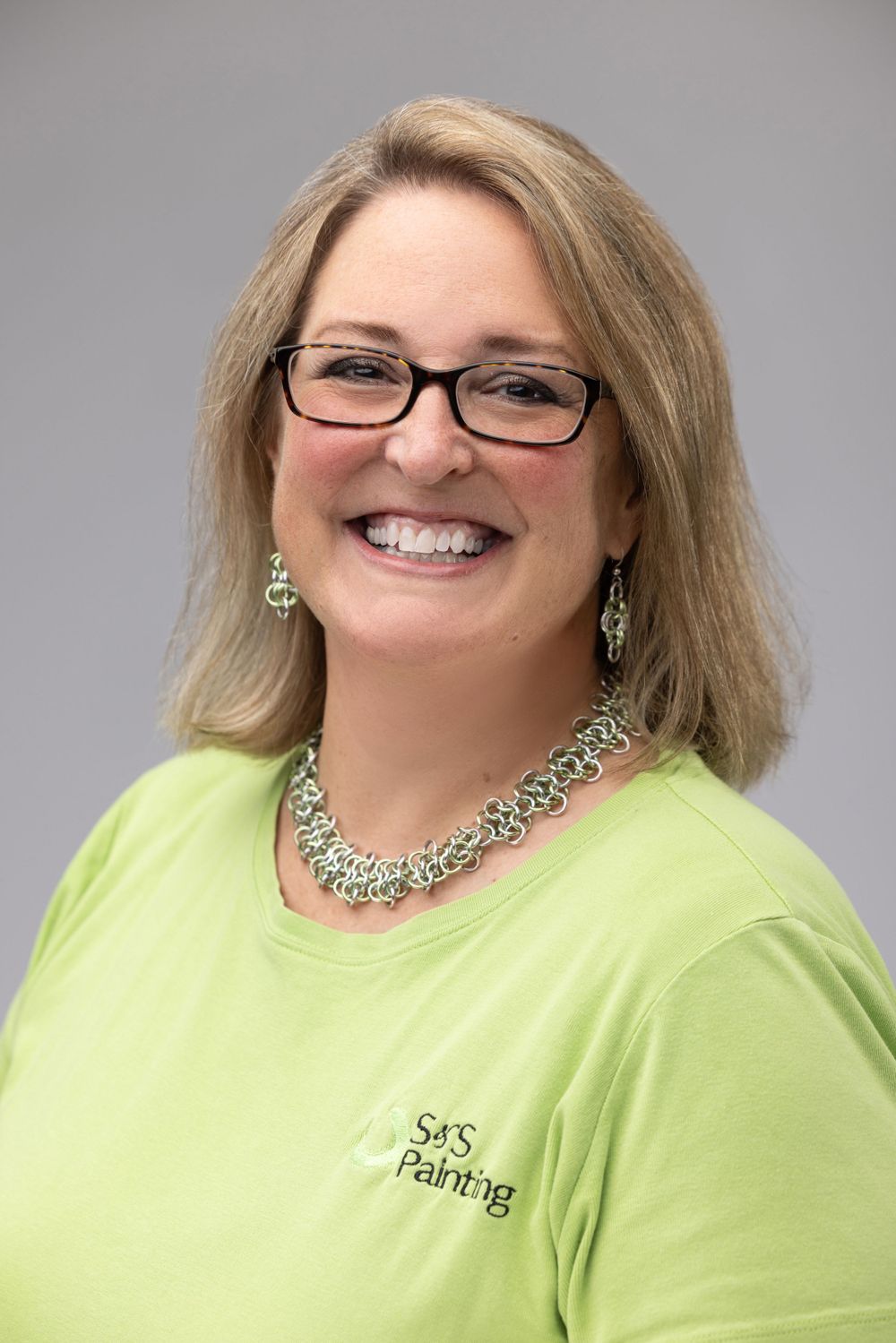 Professional headshots of person in lime green shirt against gray background.