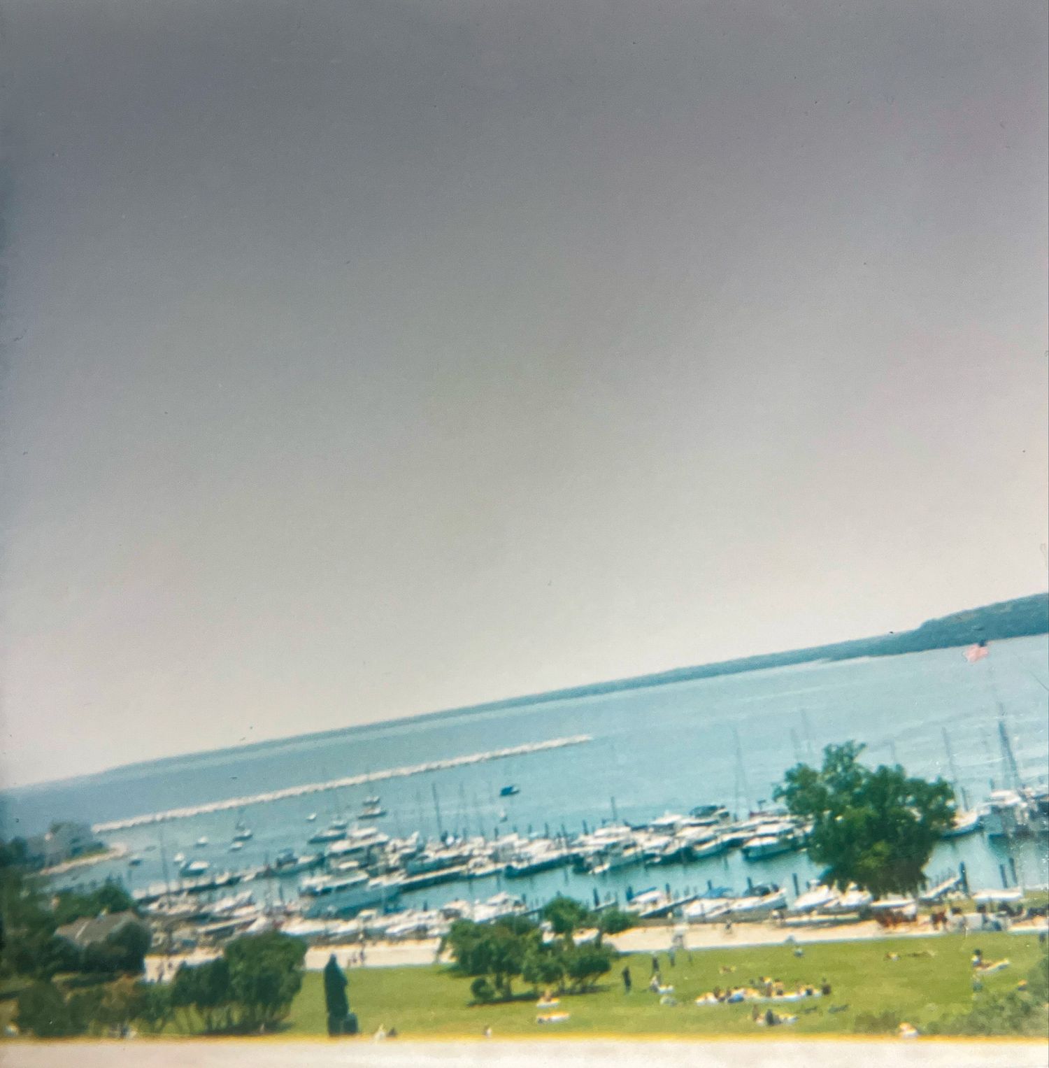 Retro square photograph of lakefront harbor taken on film.