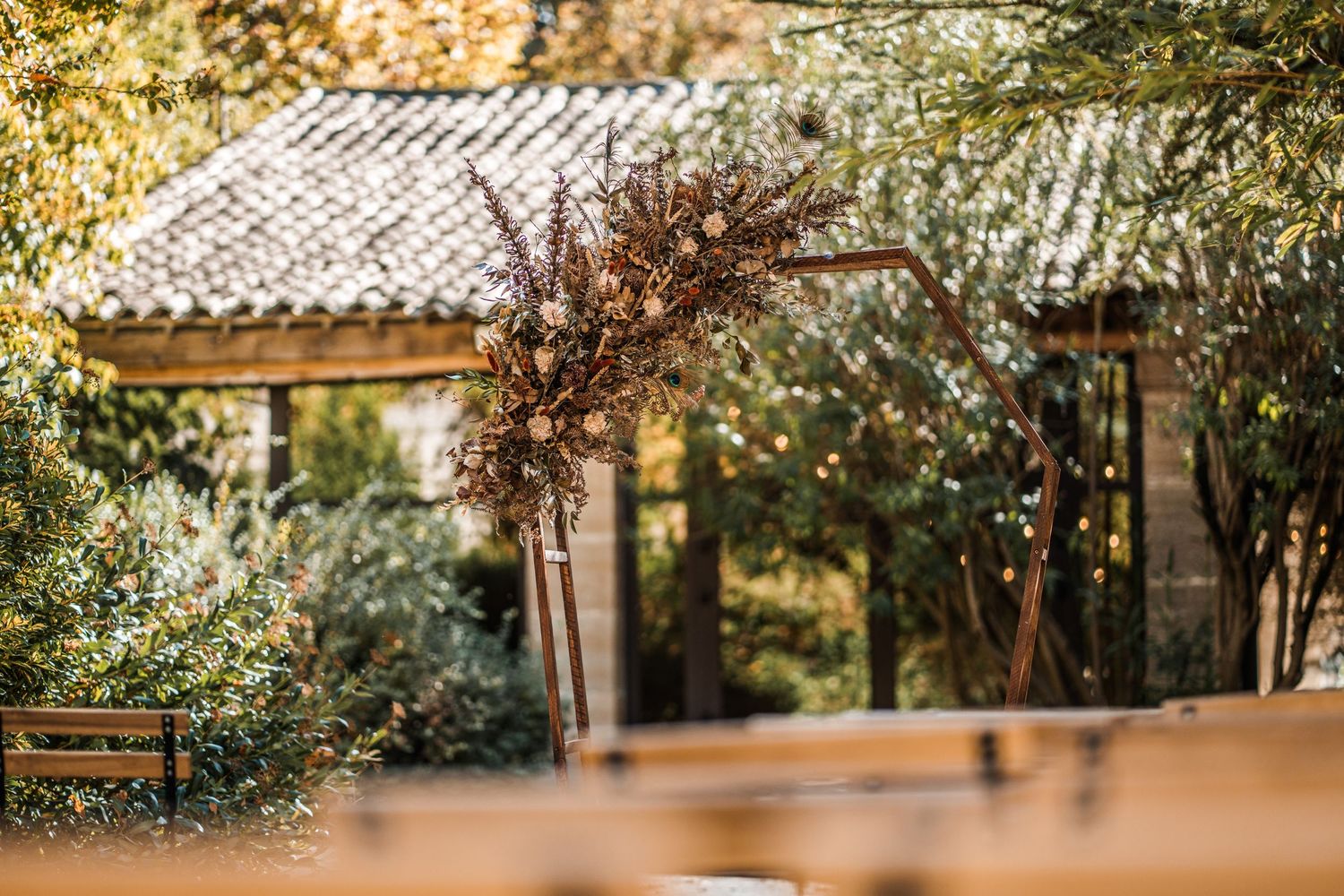 Mediterranean garden with tiled roof building and sunlit trees.