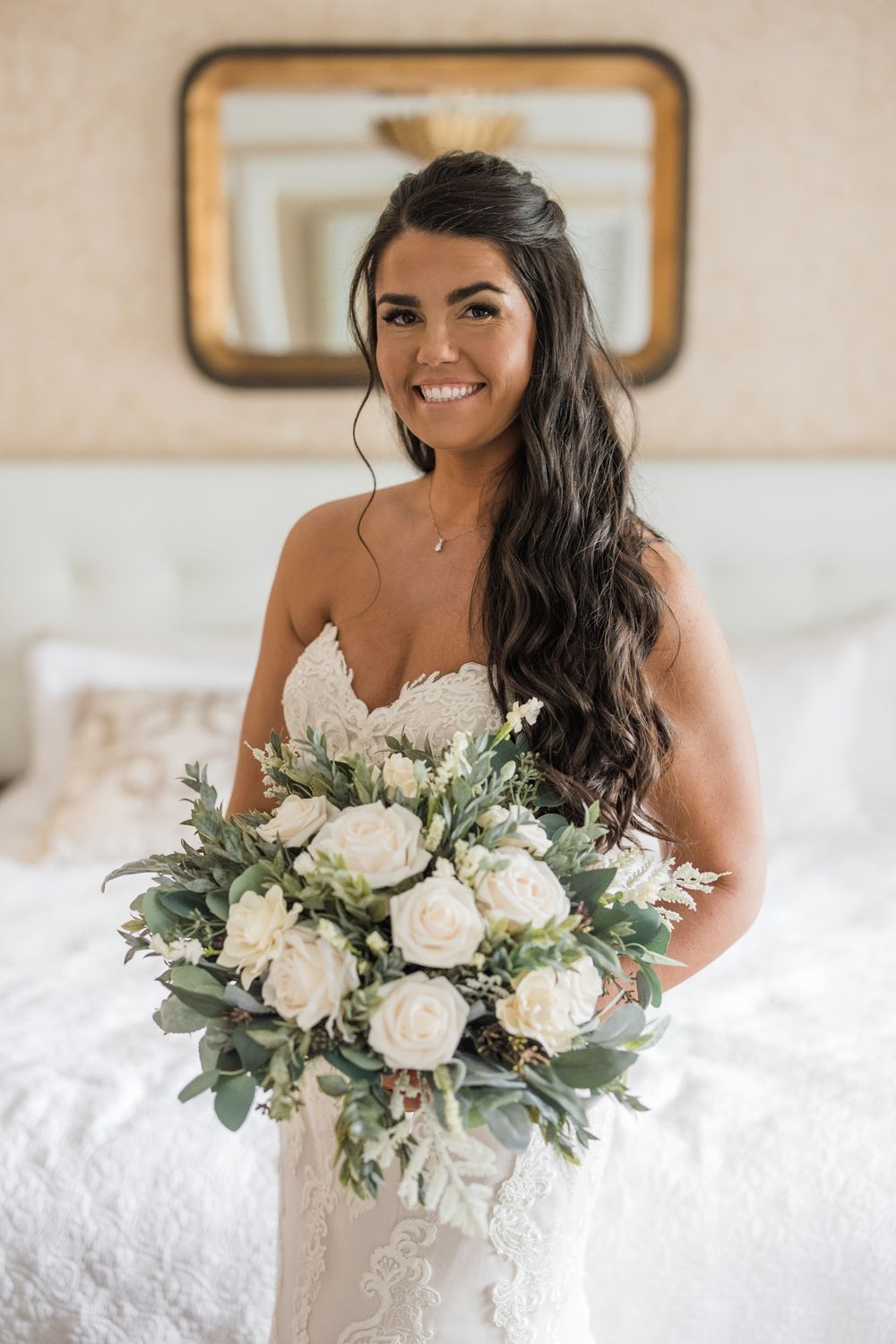 Bride holding beautiful white rose and eucalyptus wedding bouquet.