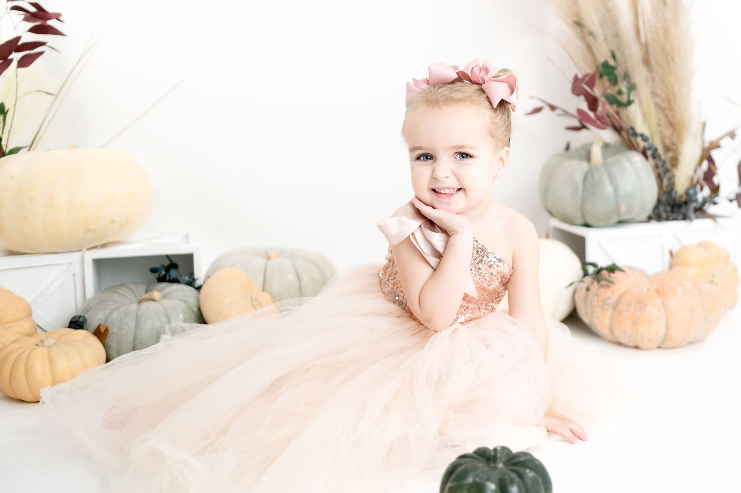 Light and airy autumn photography setup with pale pumpkins and pampas grass decorations.