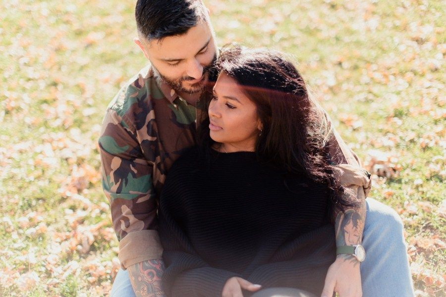 Couple sharing an intimate moment in a sunlit field.