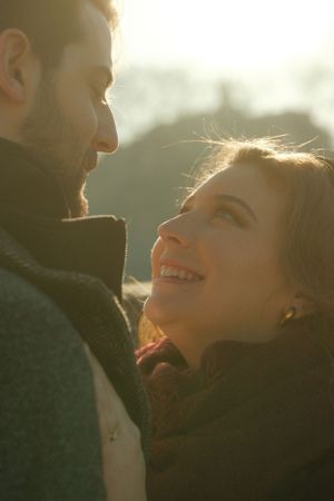 A tender moment captured in warm sunlight as two people gaze at each other.