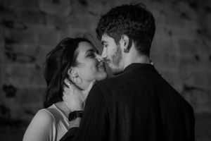 Romantic couple sharing intimate moment in atmospheric black and white portrait.