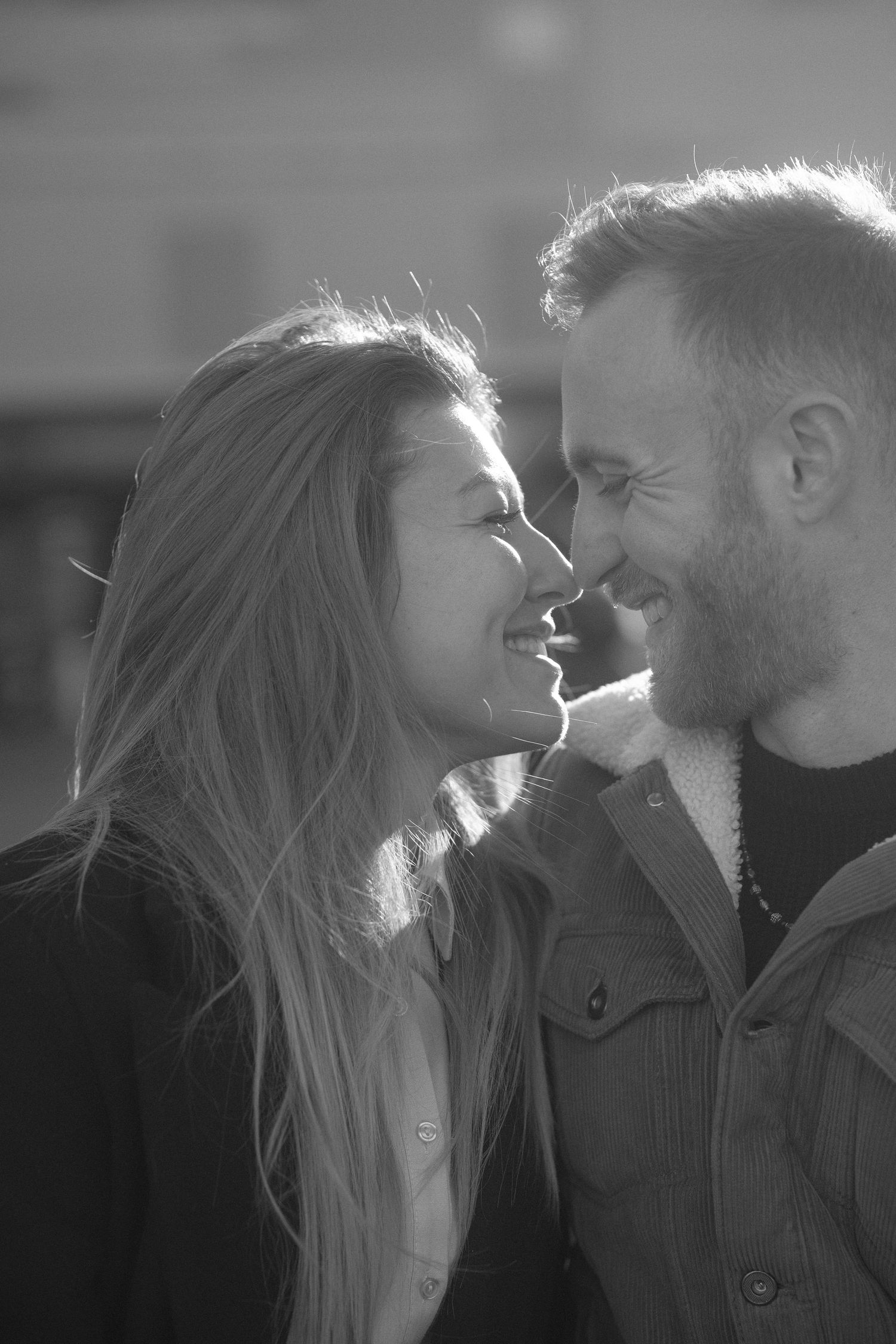 An intimate close-up portrait of a couple sharing a tender moment in black and white.