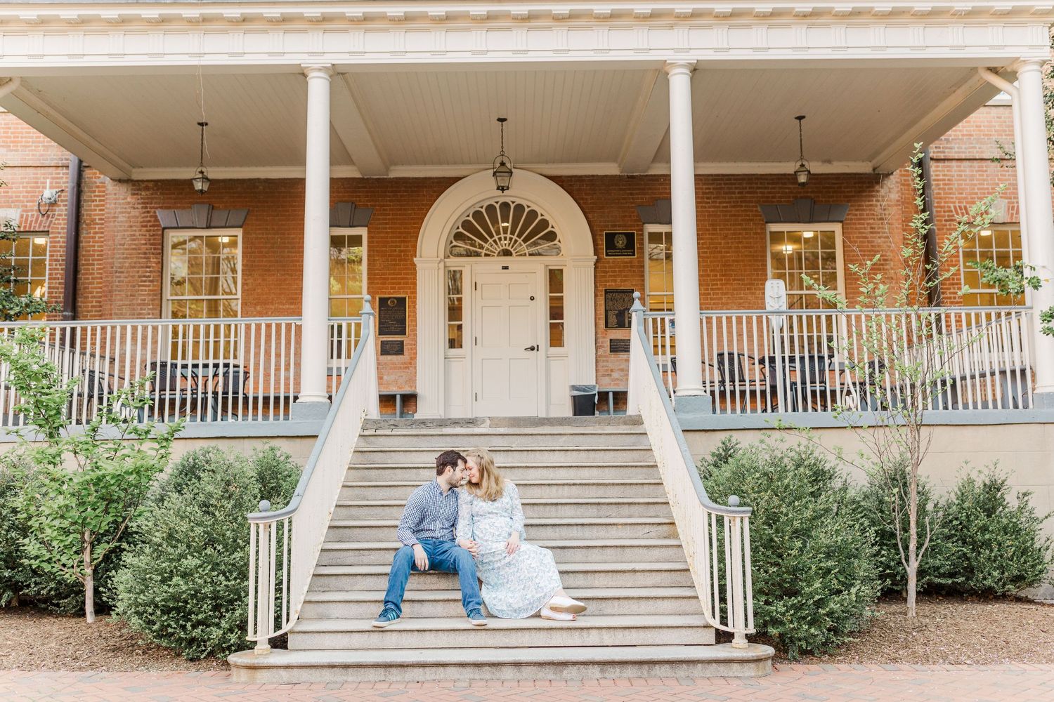 A white porch with columns frames a romantic scene on a sunny day.