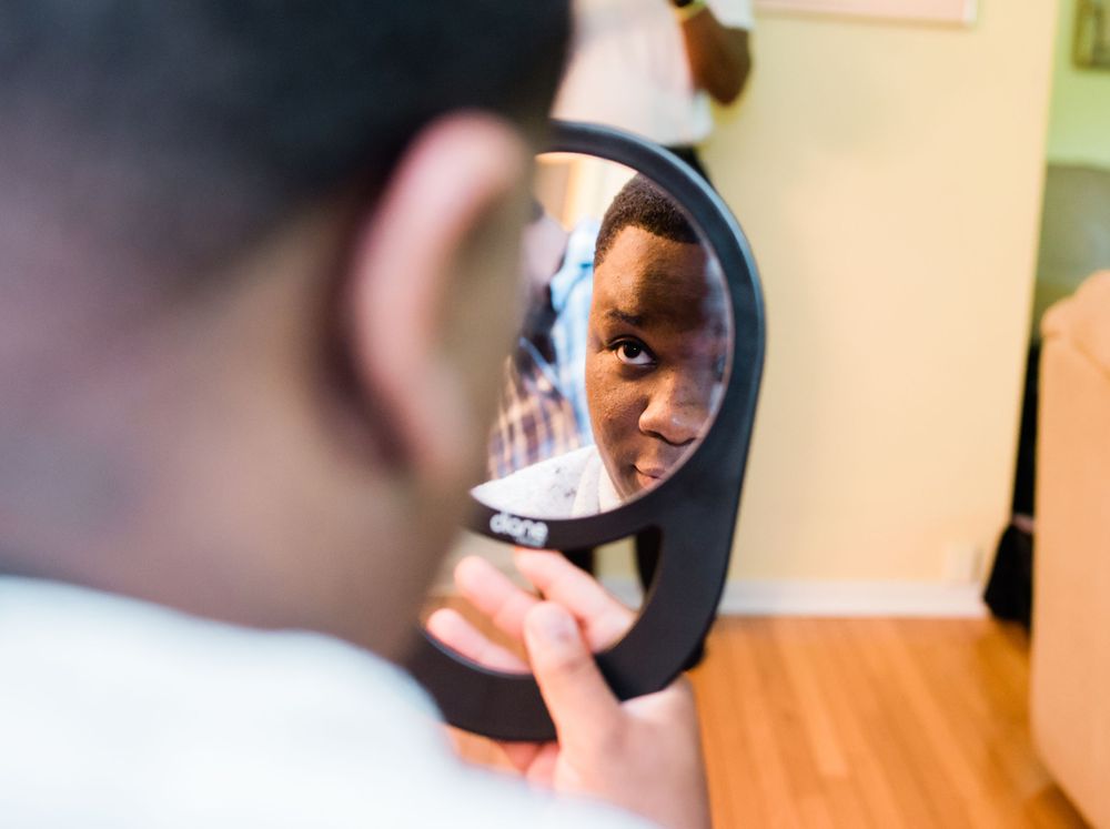 groom looking at himself in mirror