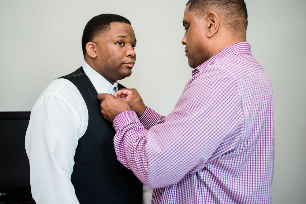 father of the groom helping groom with bowtie