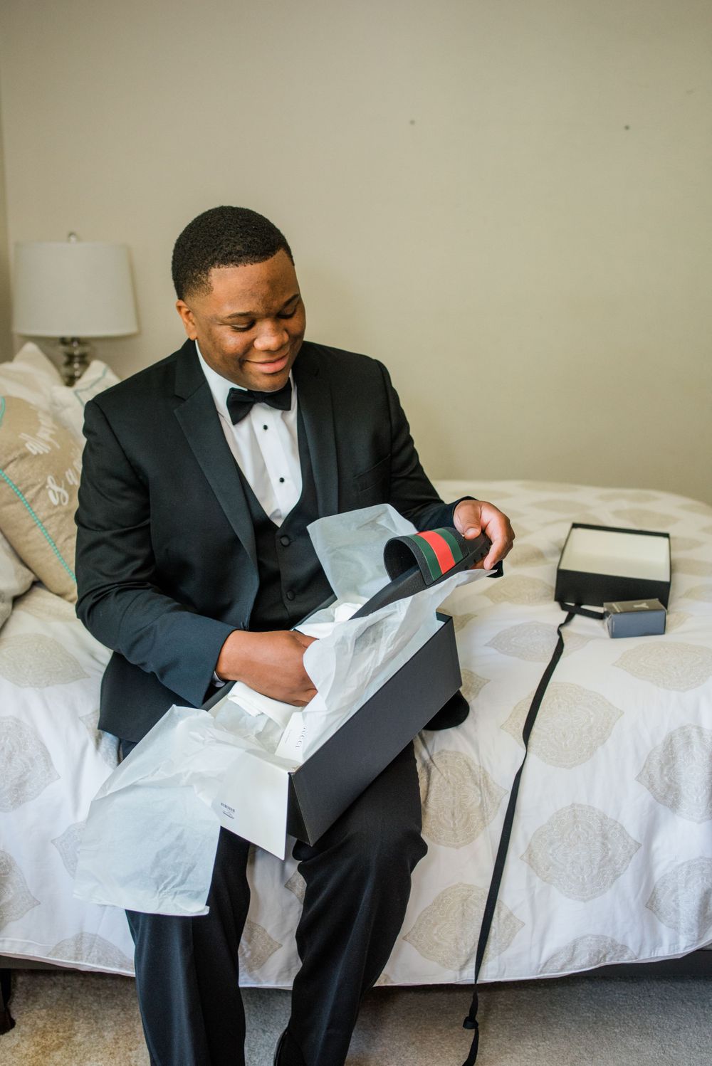 groom smiling opening wedding gift box