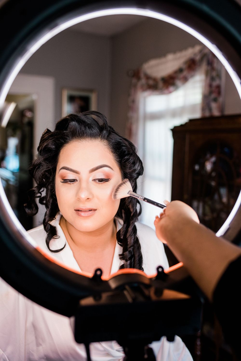 bride getting ready in front of a ring light